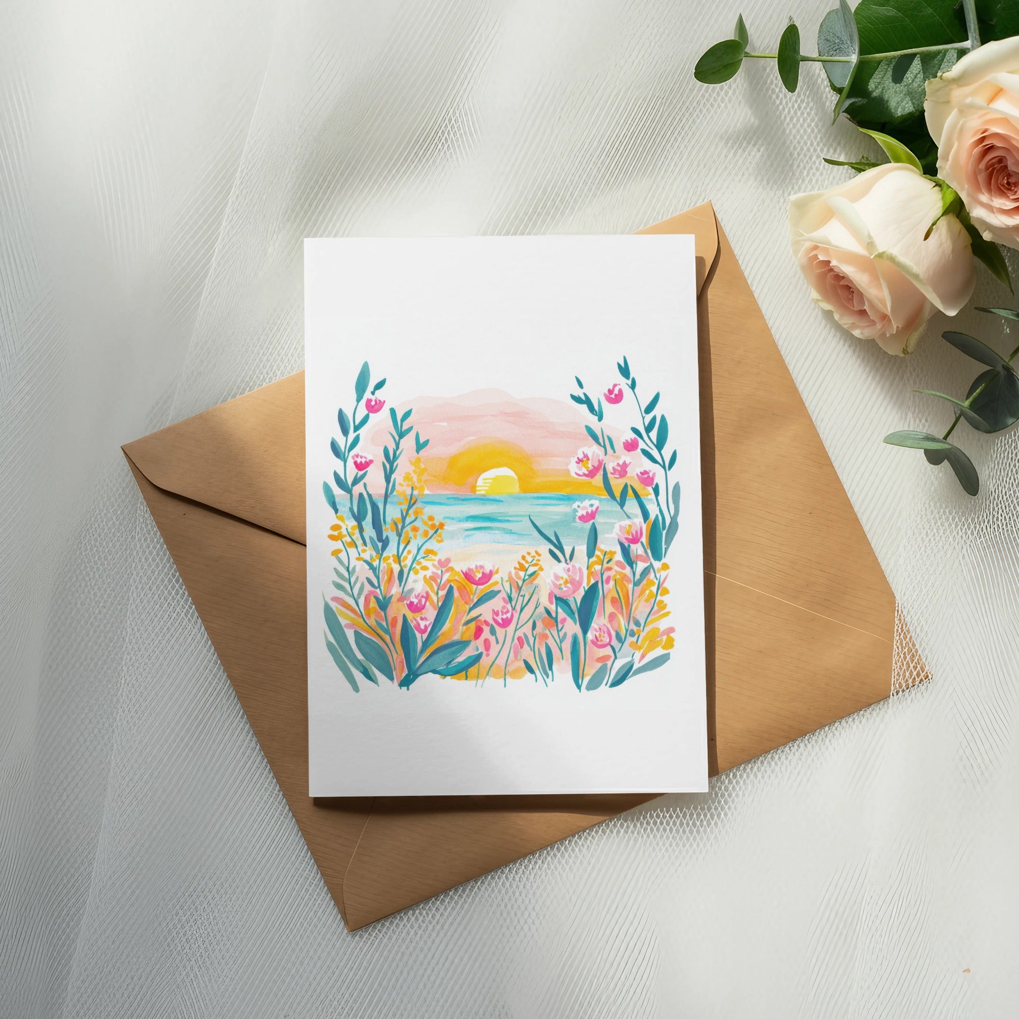 Watercolor seascape with sunset and flowers on a card, atop a brown envelope.