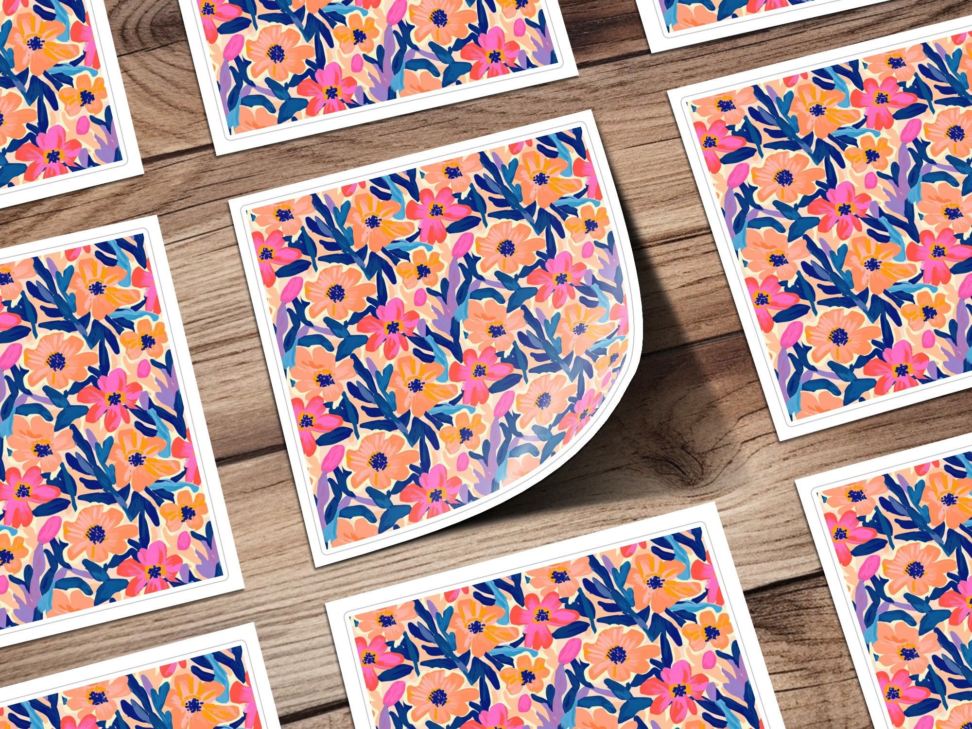 Floral pattern with pink, blue, and orange flowers on a wooden background.