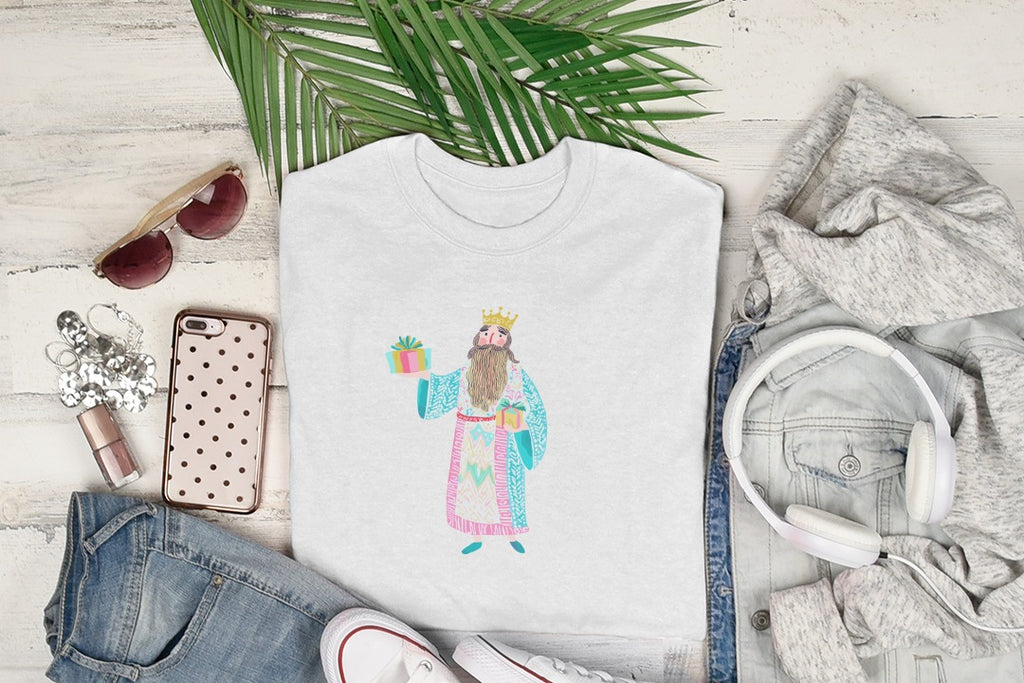 White t-shirt with cartoon King holding gift and presents laid out.