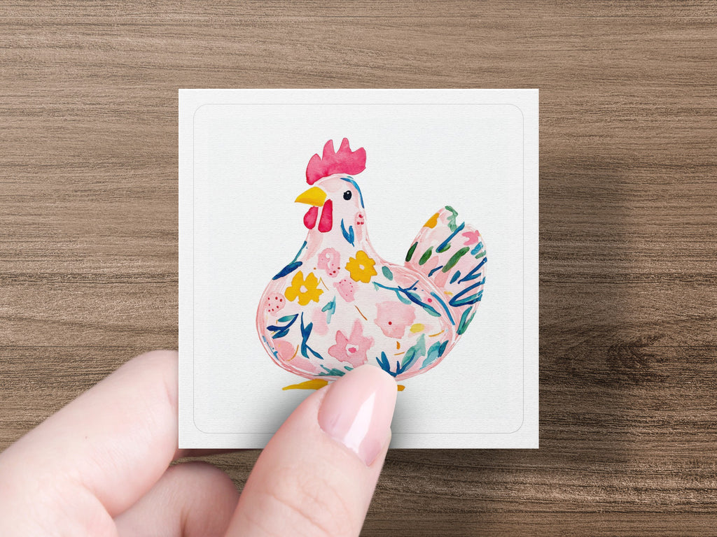 Watercolor chicken with floral pattern held by a hand.
