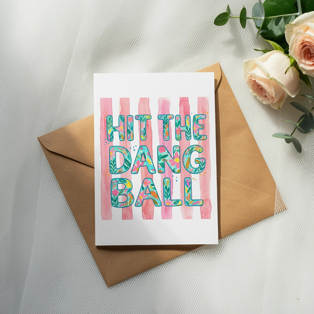 Greeting card with "Hit the ball" text and pink stripes on a brown envelope.