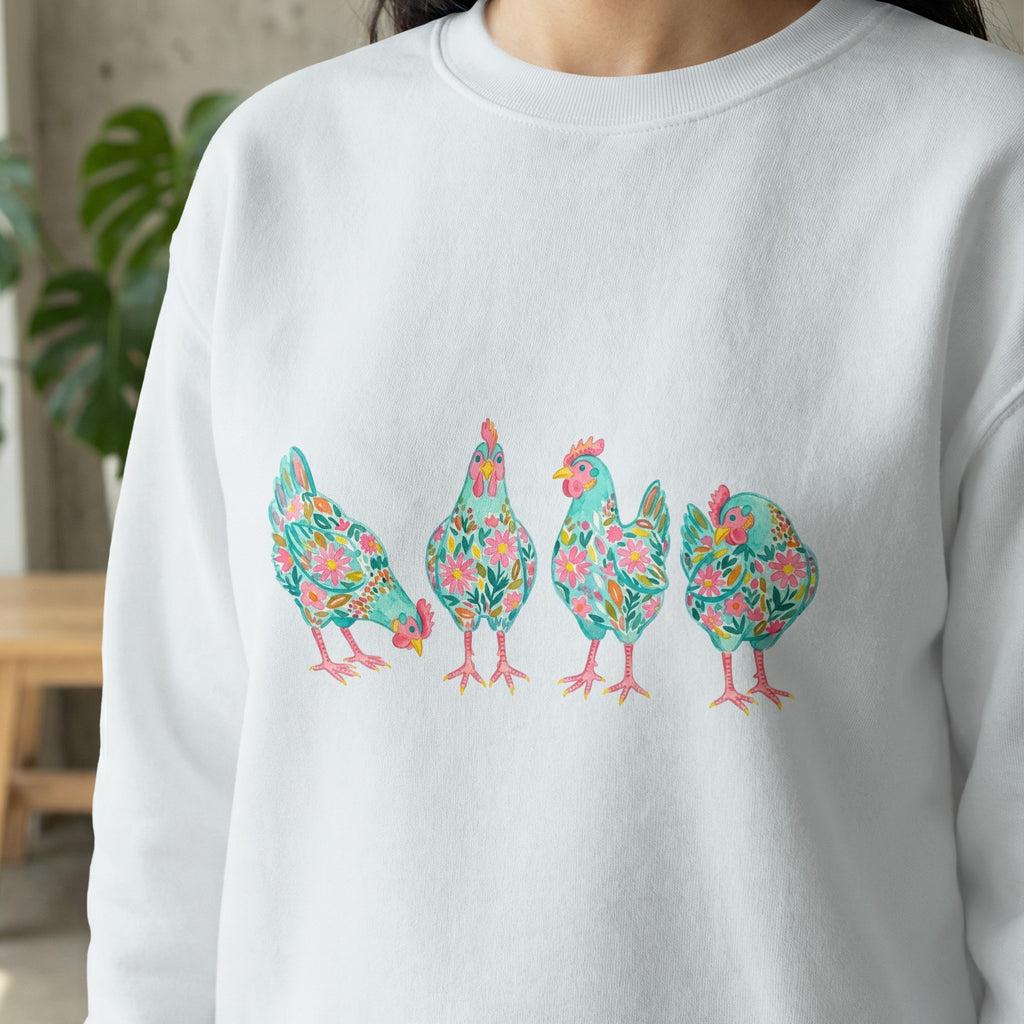 White sweatshirt with four colorful floral watercolor chickens across the chest.