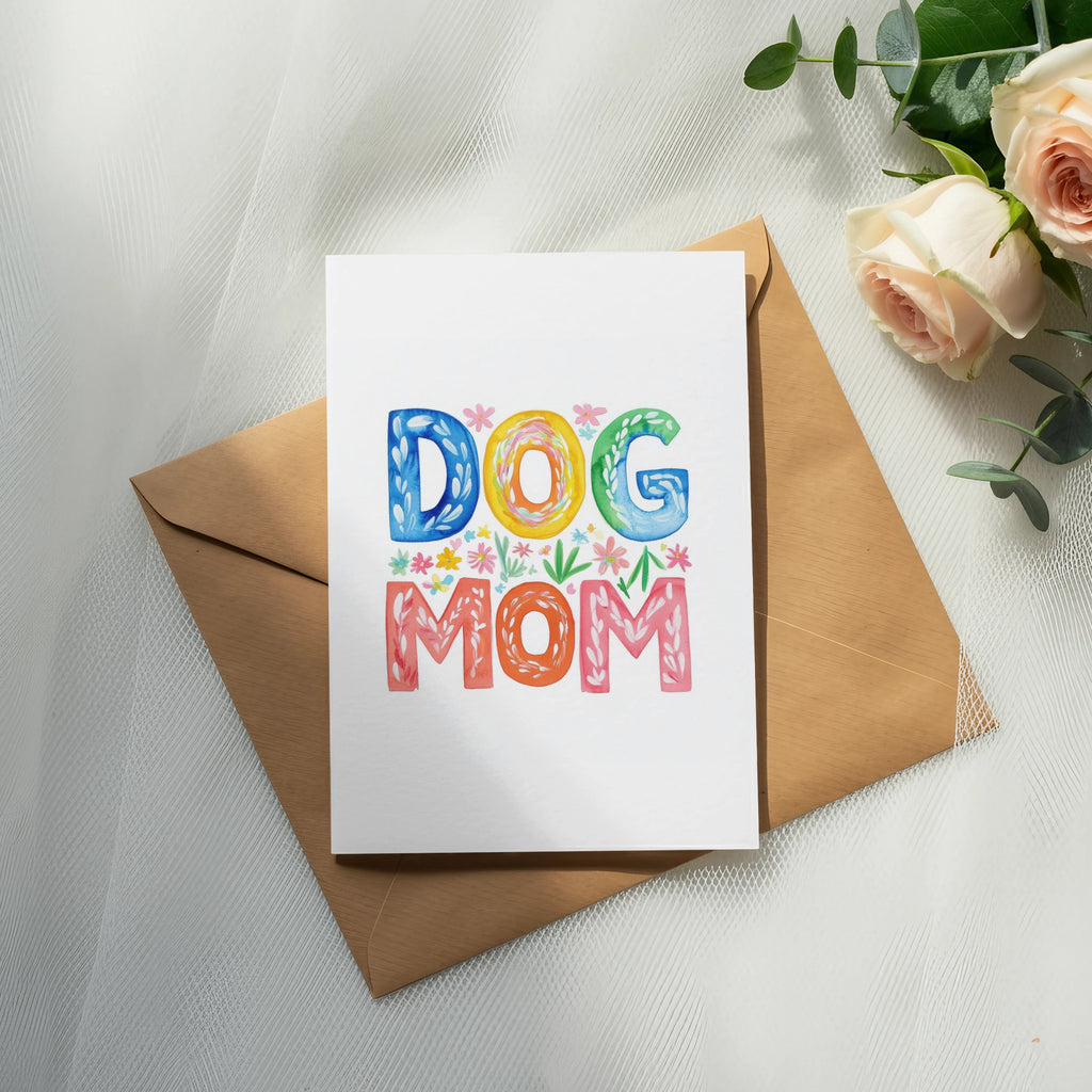 Card with "DOG MOM" in colorful letters on envelope, with roses and eucalyptus.