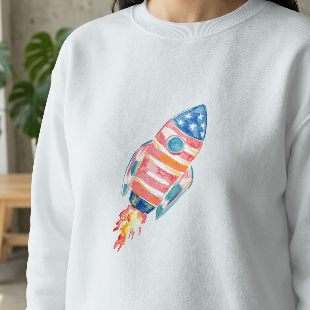 White sweatshirt with watercolor rocket ship design.