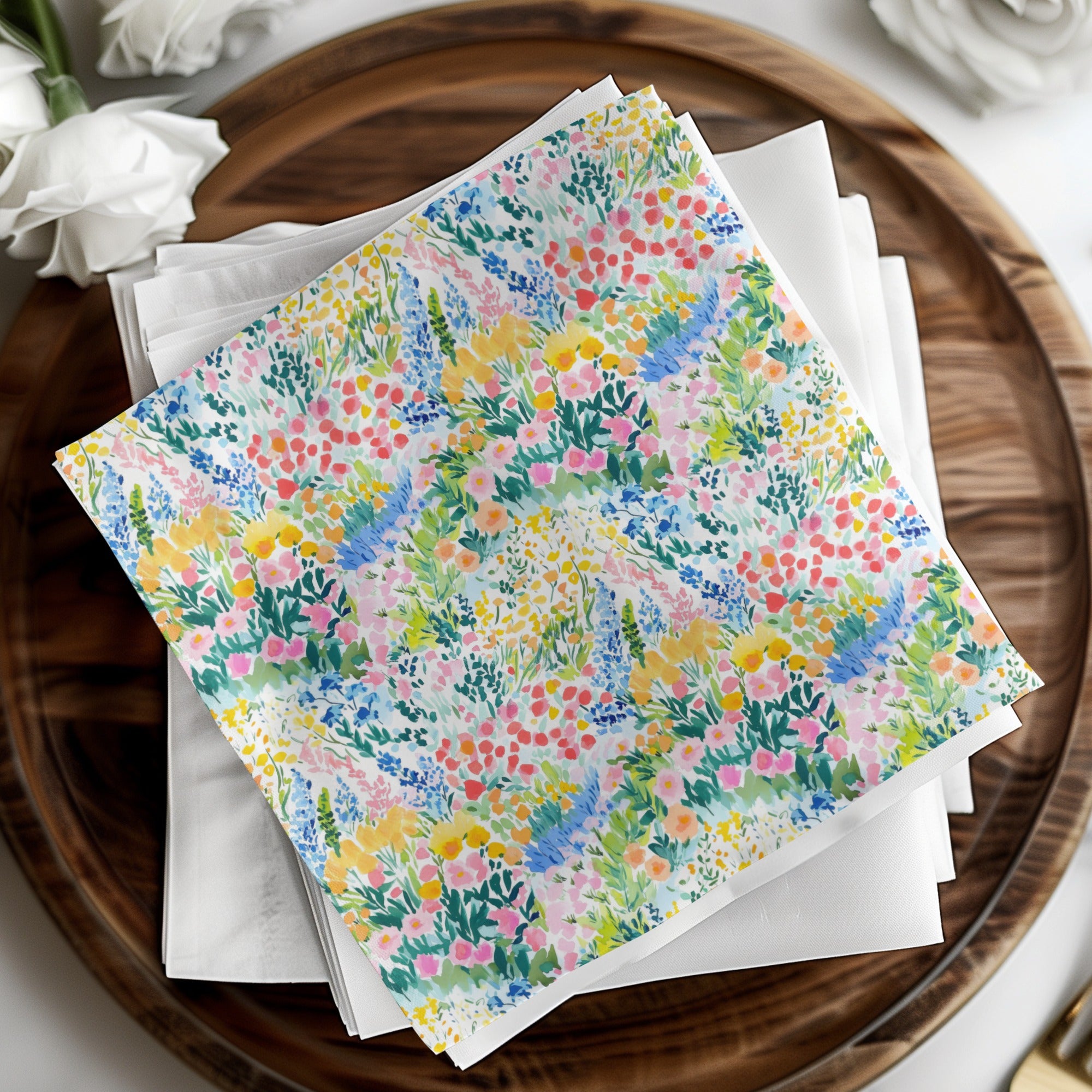 Watercolor floral print napkins stacked on a wooden tray.
