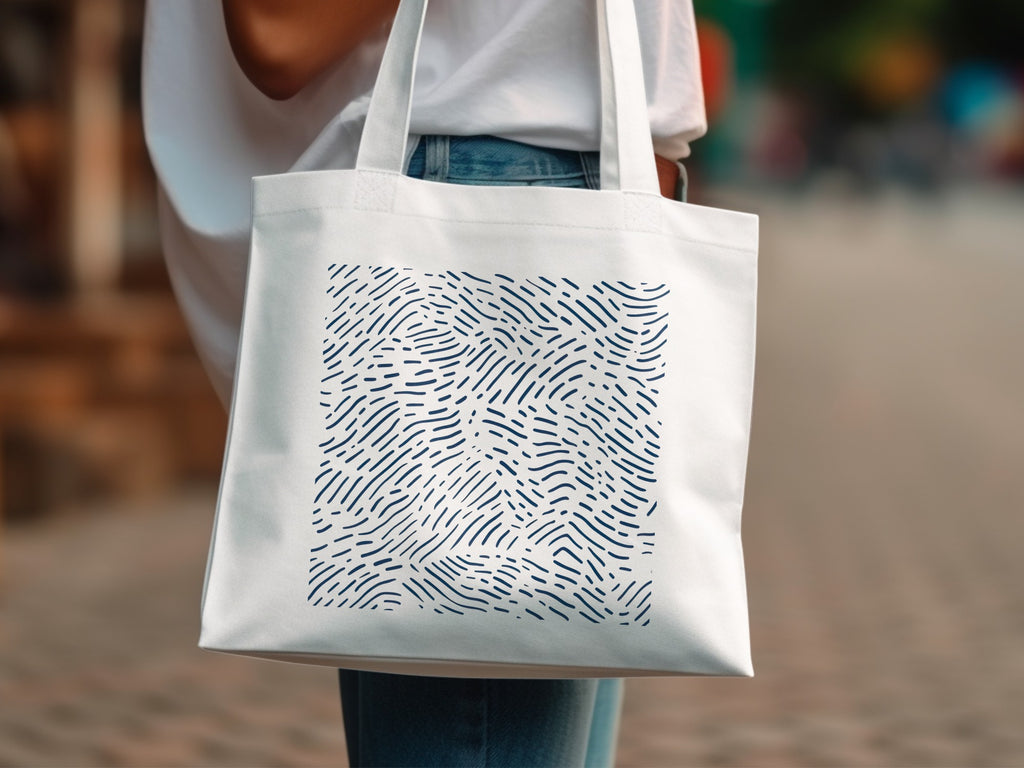 White tote bag with a dark blue abstract wavy line pattern.