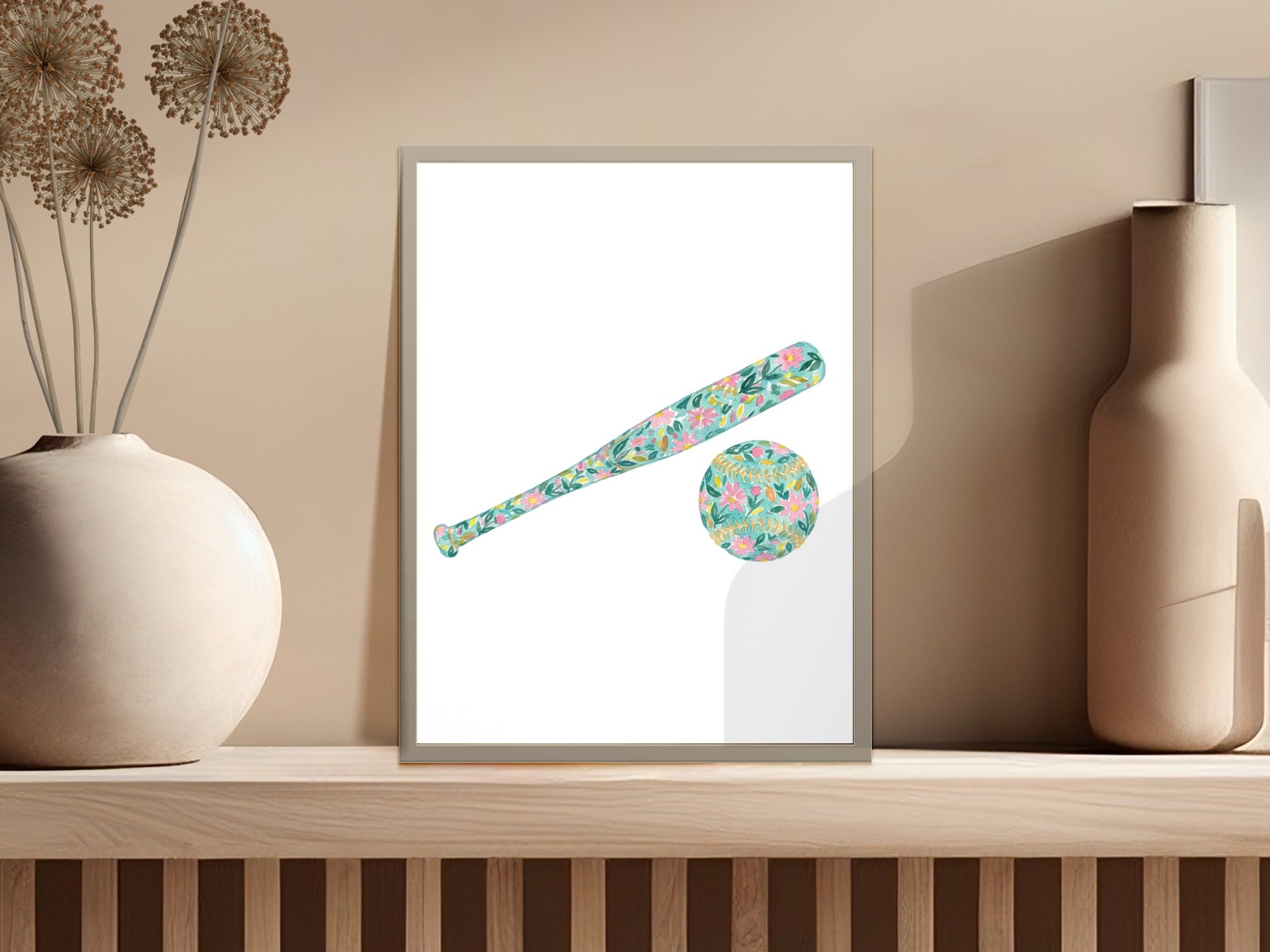 Floral baseball bat and ball artwork in a framed print on a shelf.