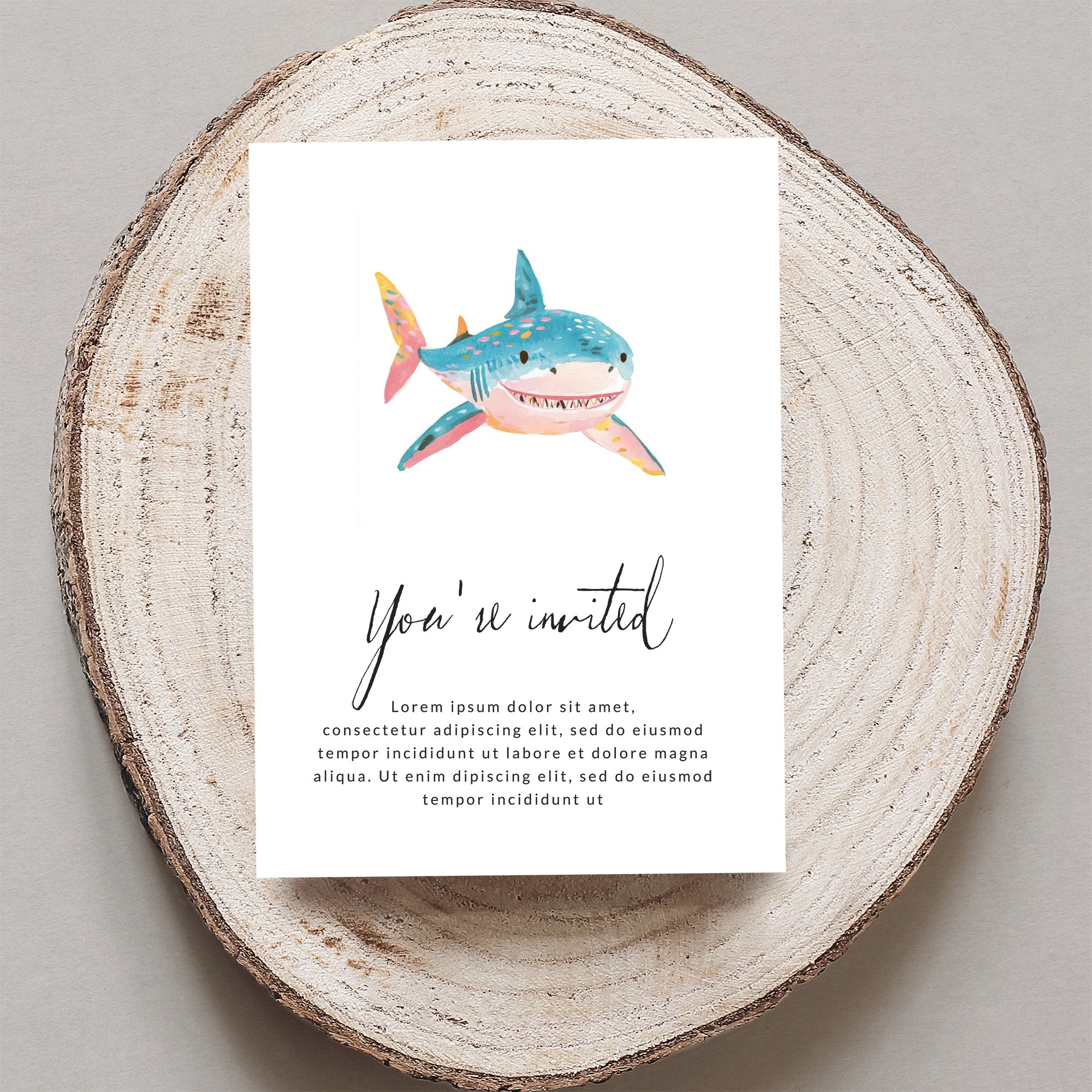 Whimsical shark illustration on an invitation with "You're invited" text.