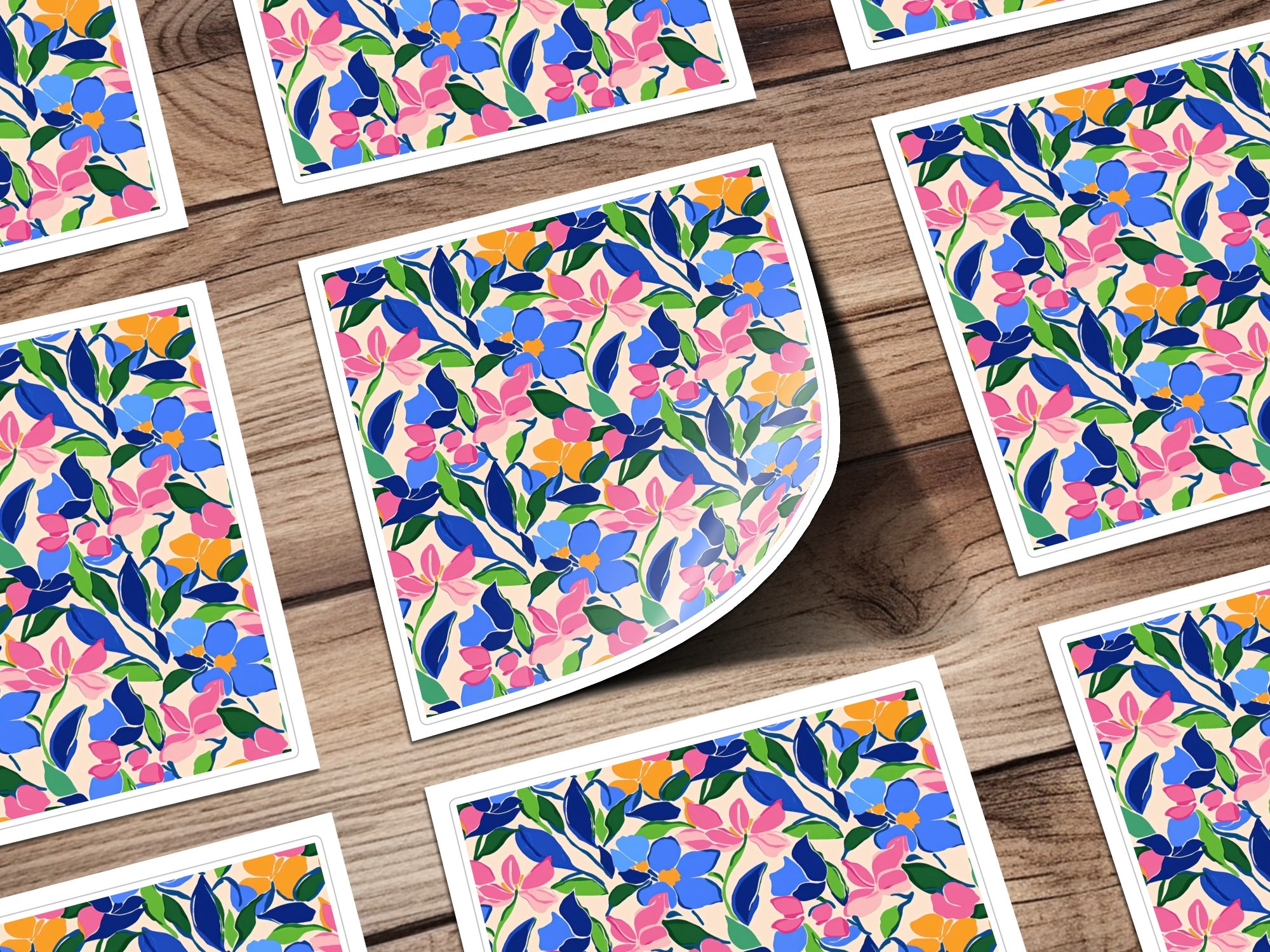 Floral patterned cards with blue, pink, and green flowers on a wooden background.