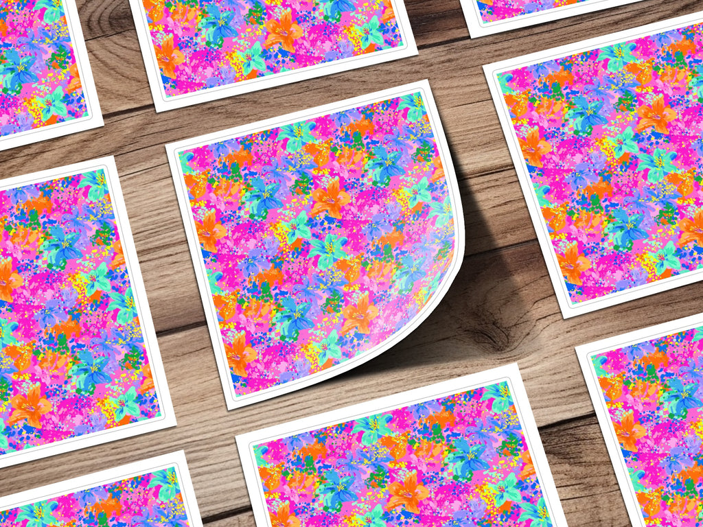 Multiple square stickers with a vibrant floral pattern on a wooden background.