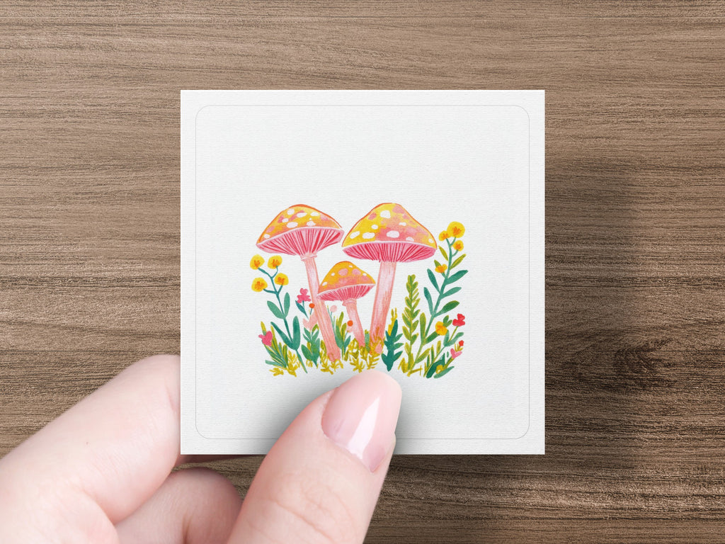Three stylized mushrooms with red spots and yellow stems on a white square.
