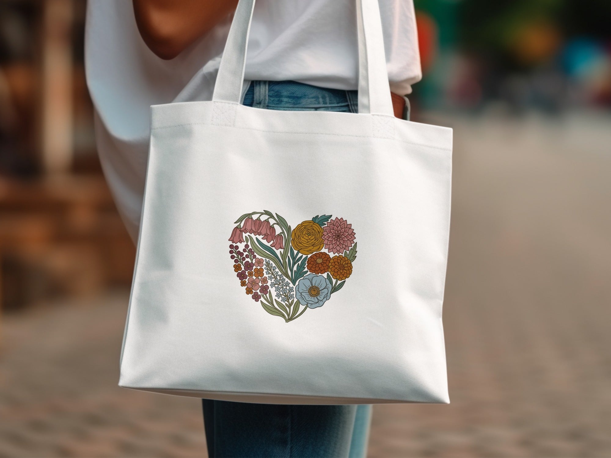 White tote bag with a heart-shaped floral illustration in muted colors.