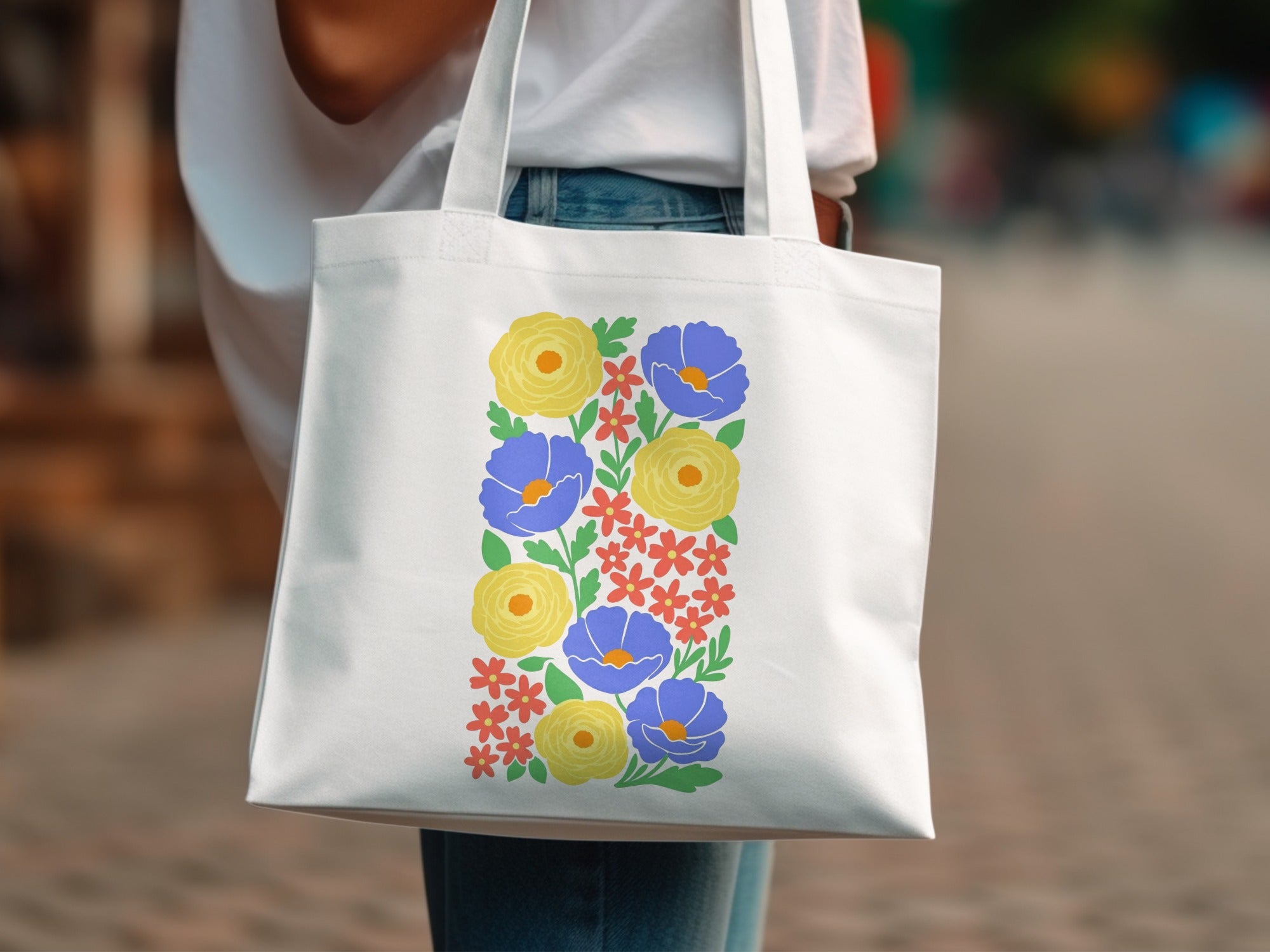 White tote bag with colorful floral pattern featuring blue and yellow flowers.