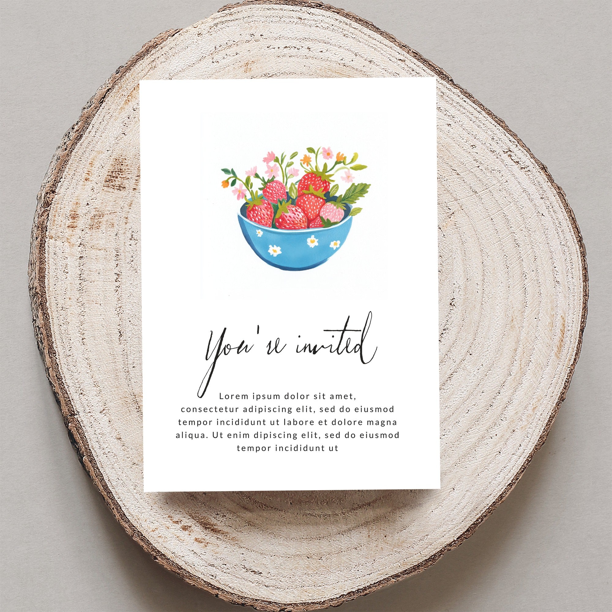 Invitation card with "You're invited" text and bowl of strawberries.