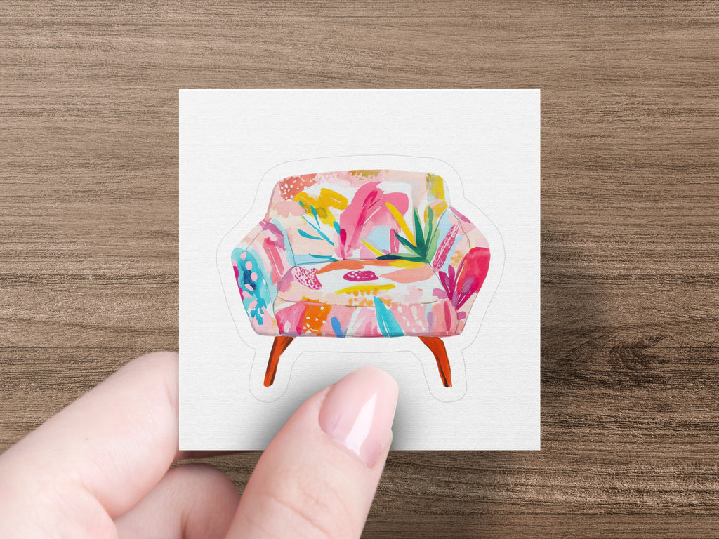 Armchair with bright floral upholstery, held by a hand.