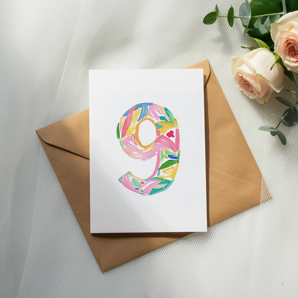 White card with "9" in colorful floral watercolor design on envelope.