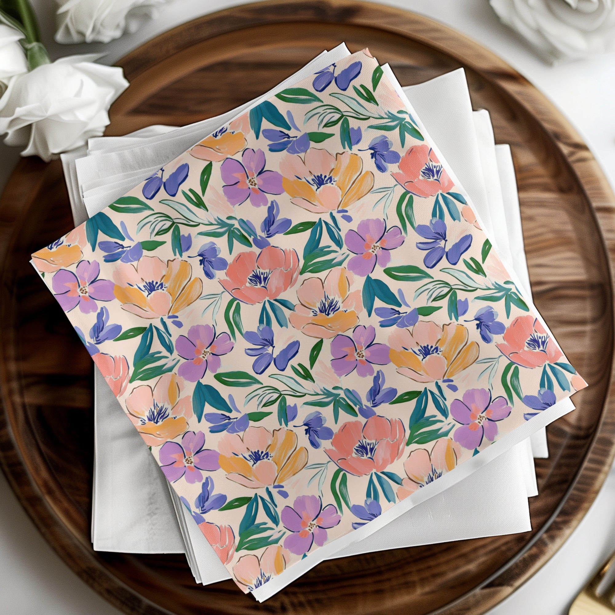 Floral patterned napkins in pink, purple, and blue on white napkins.