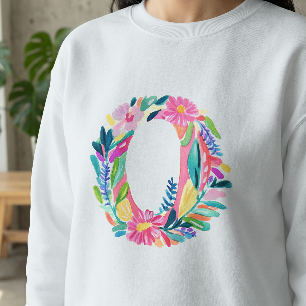 White sweatshirt with a large, colorful floral letter O design.