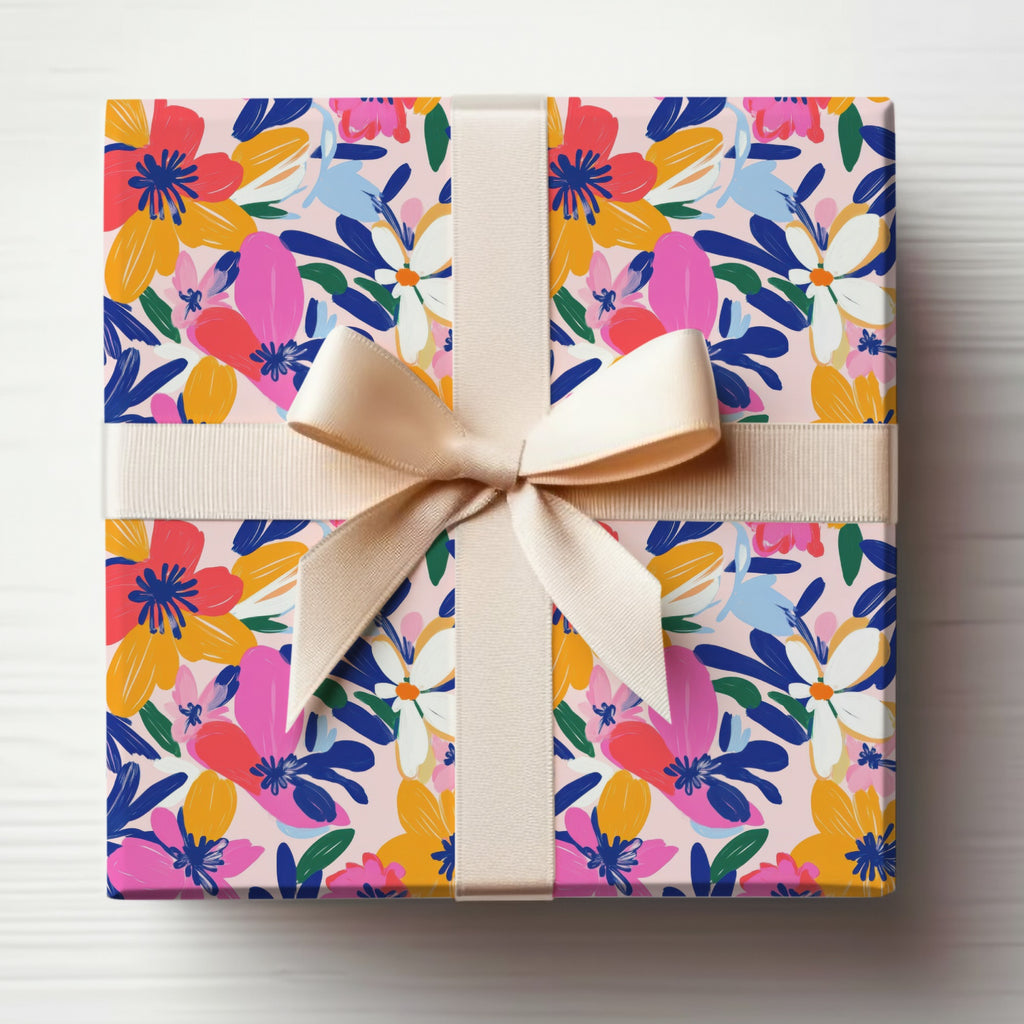 Gift box wrapped in floral paper with a light pink ribbon bow.