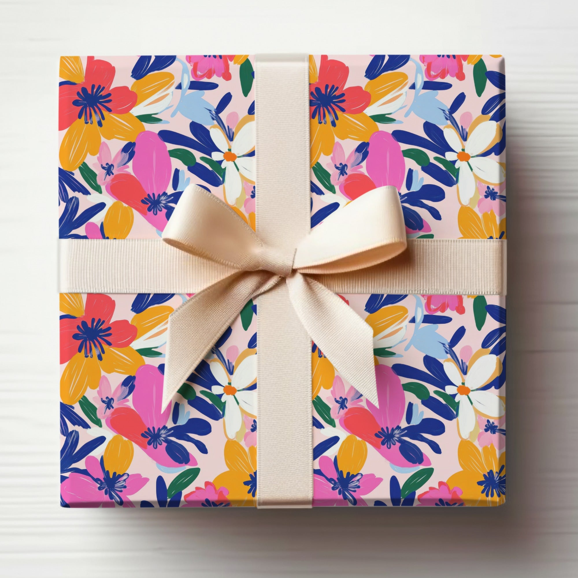 Gift box wrapped in floral paper with a light pink ribbon bow.