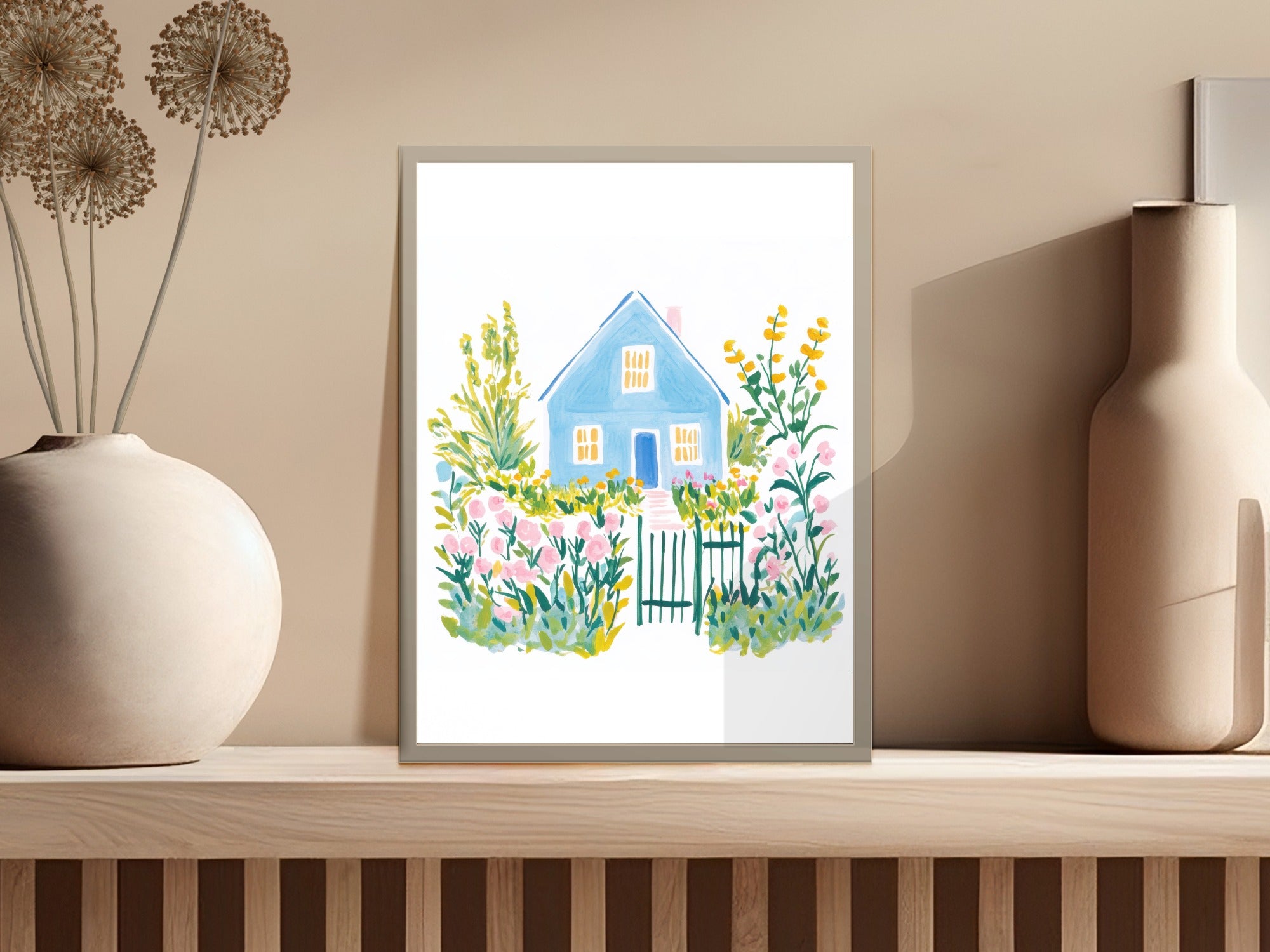 Blue watercolor house with flowers and picket fence in a framed print.