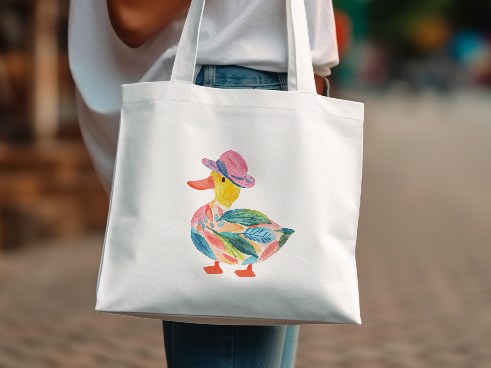 White tote bag with colorful watercolor duck wearing a pink hat.