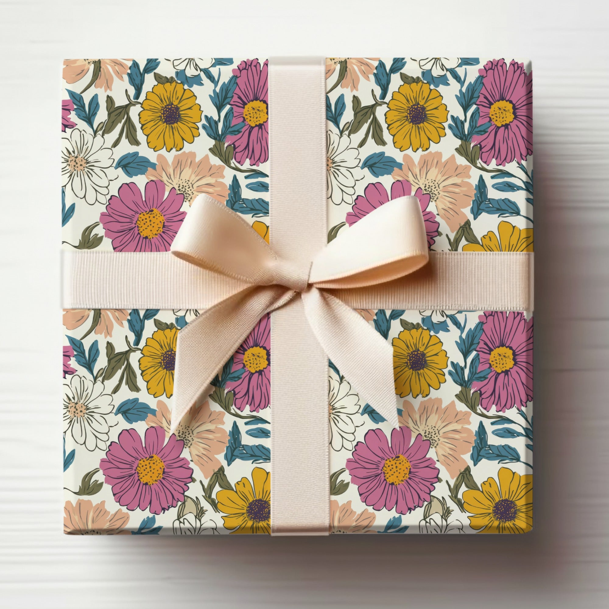 Gift-wrapped box with pink ribbon, featuring a floral pattern of yellow and pink flowers.
