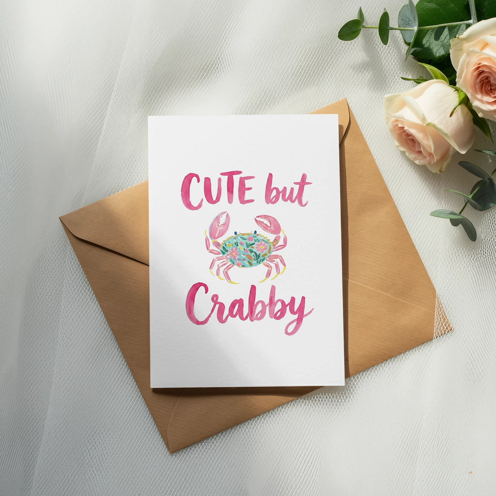 Card with "Cute but Crabby" text and pink crab illustration on brown envelope.