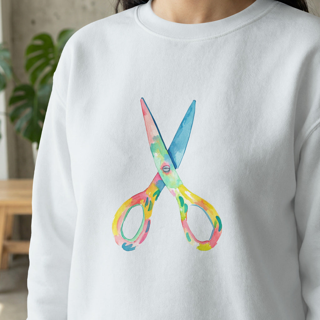 Watercolor scissors graphic on white crewneck sweatshirt.