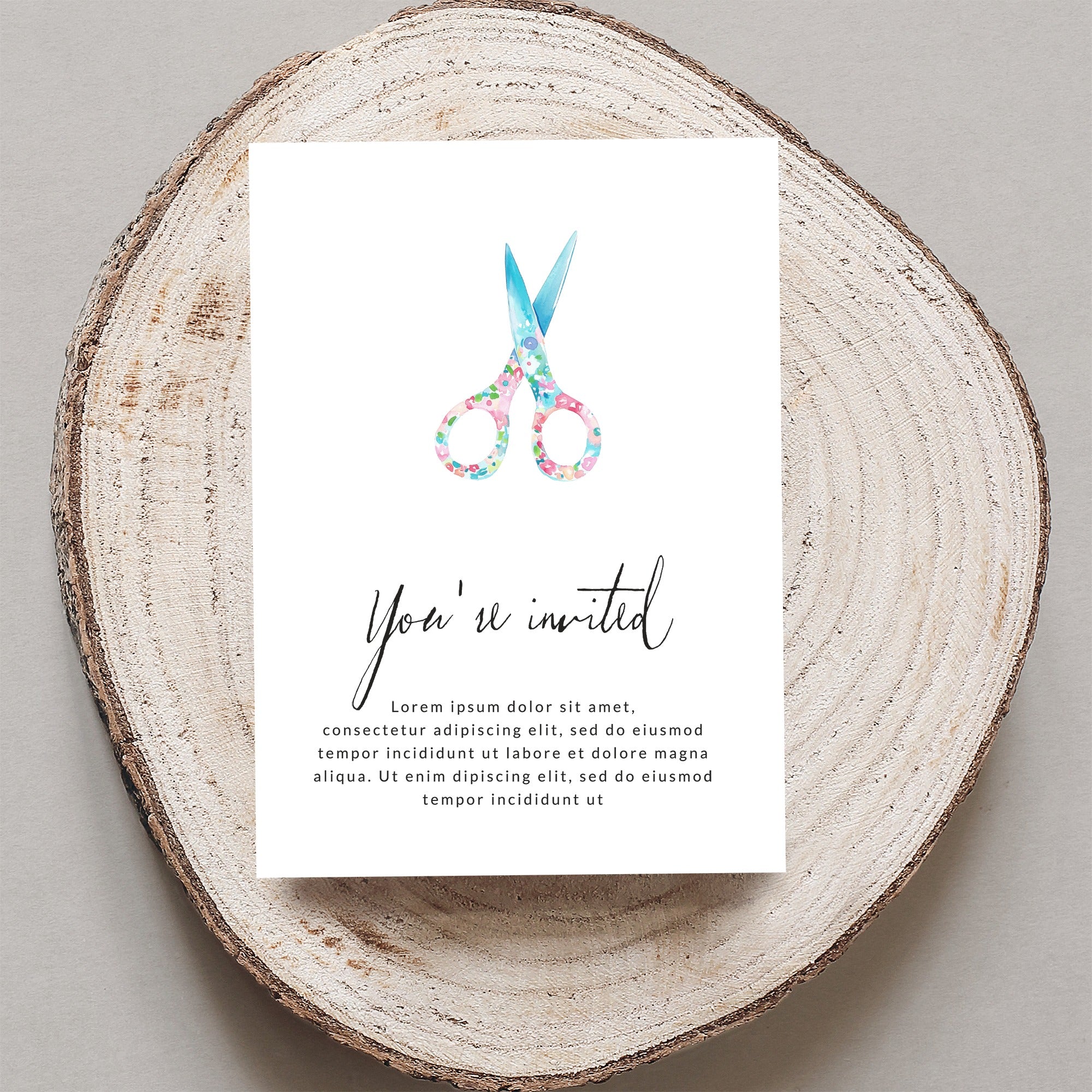 Watercolor scissors on invitation card with "You're invited" text.