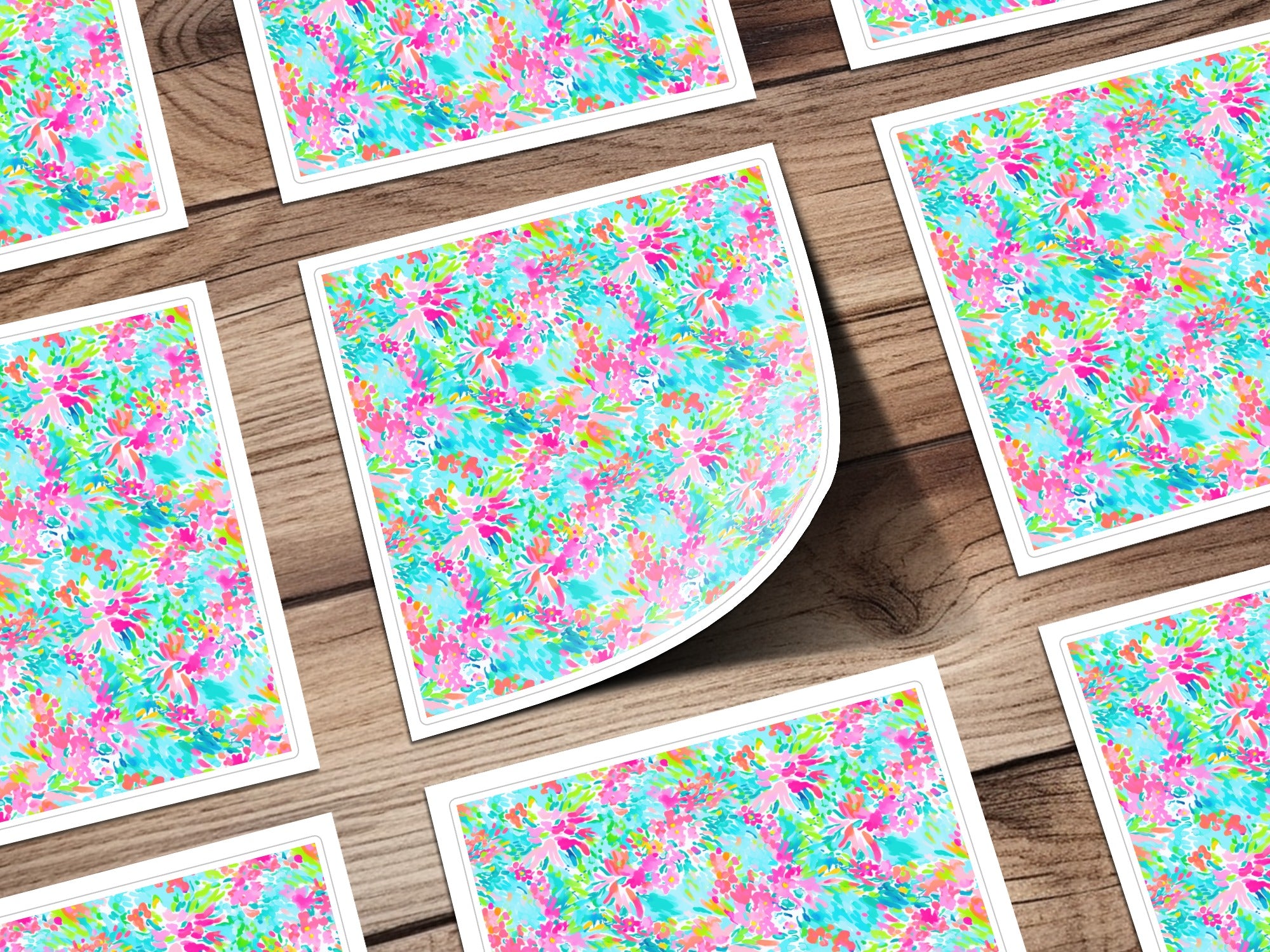 Floral pattern on white cards with rounded corners on a wooden surface.