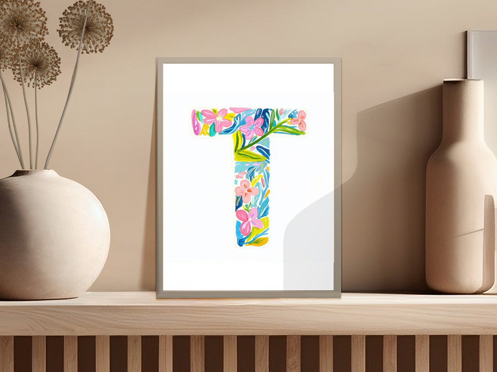 Colorful floral letter T art print on a shelf with vase.