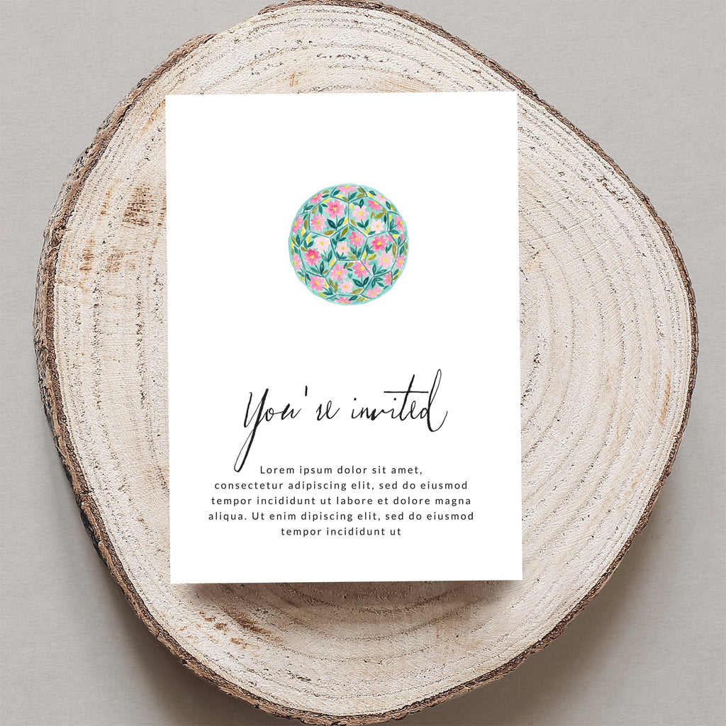 Invitation with "You're invited" text and floral illustration on wood slice.
