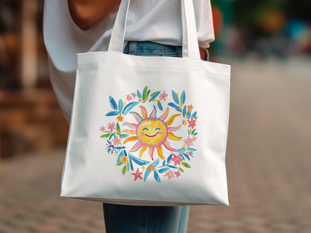 White canvas tote bag featuring a watercolor illustration of a smiling sun with colorful floral accents.