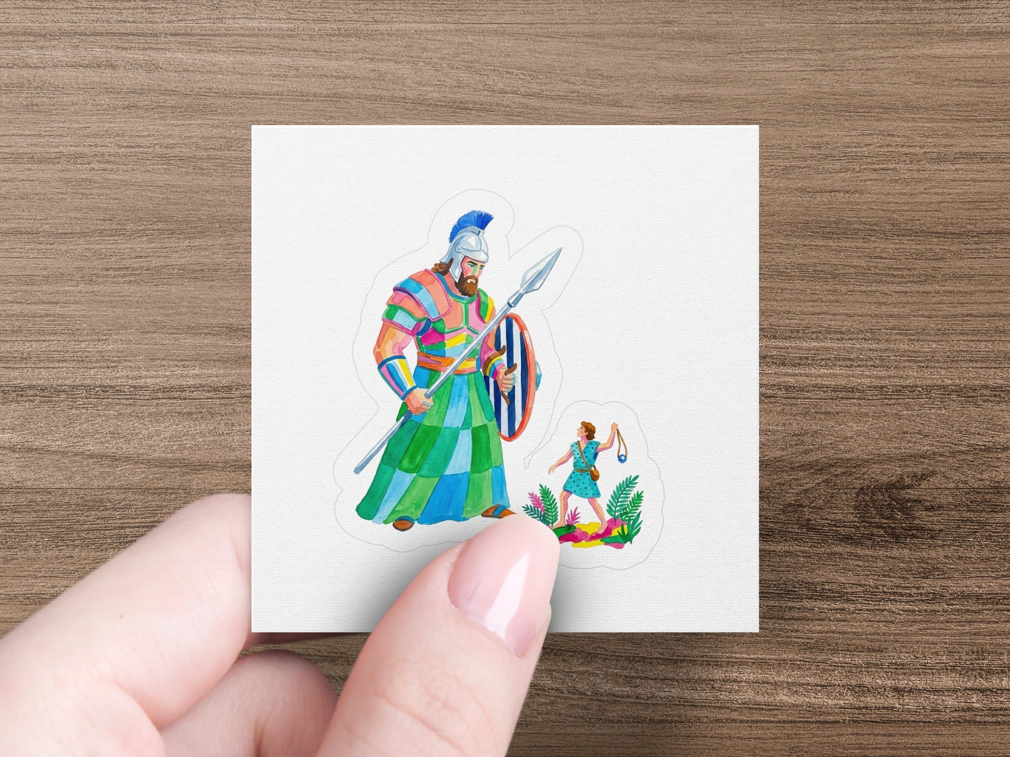 Illustration of David and Goliath in colorful warrior attire, fighting on a grassy hill.