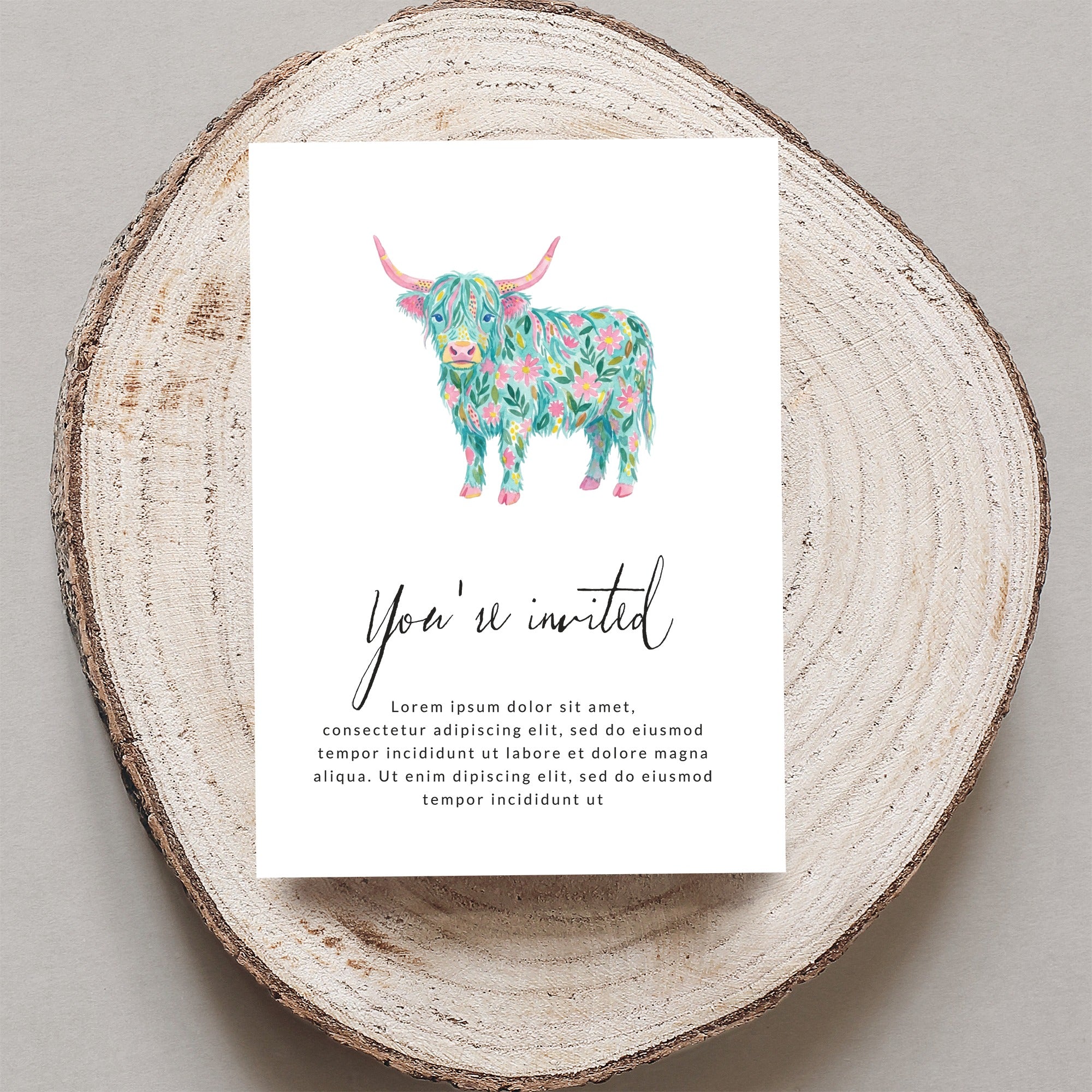 Invitation with a floral Highland cow illustration and "You're invited" text.