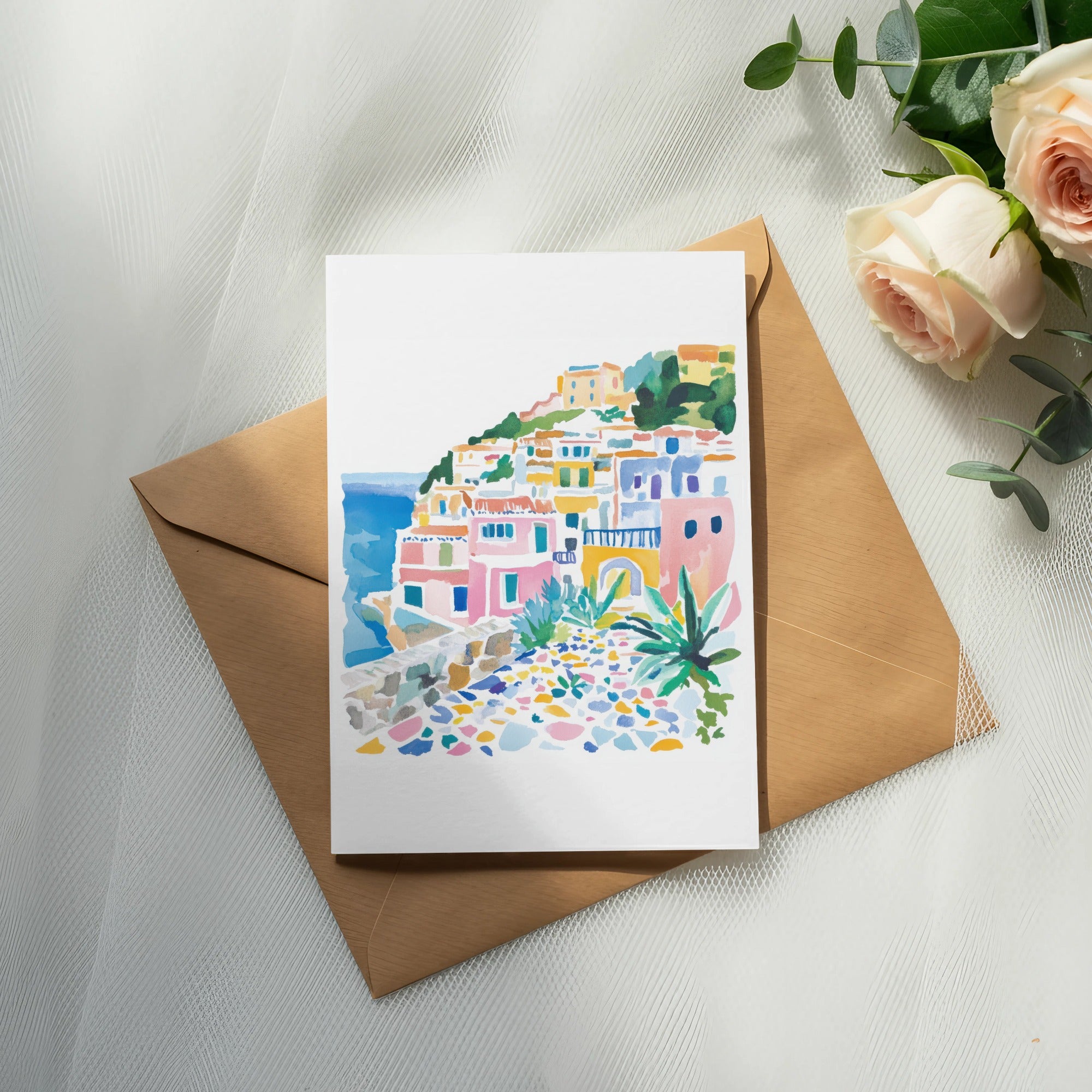Watercolor painting of colorful Italian coastal village on brown envelope with roses.