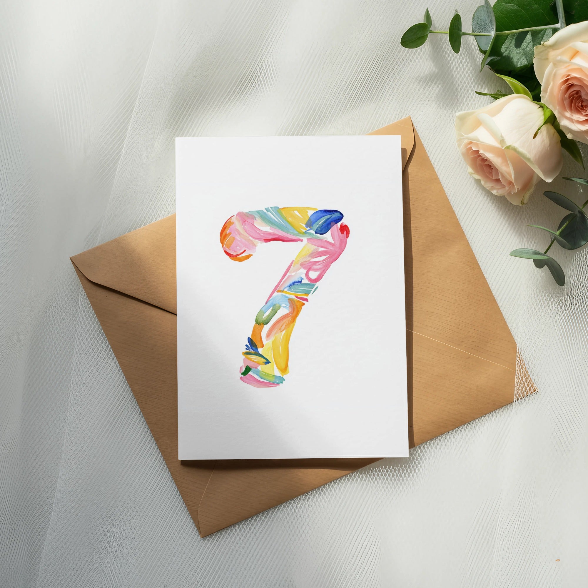 Watercolor number seven painted on white cardstock, on brown envelope.