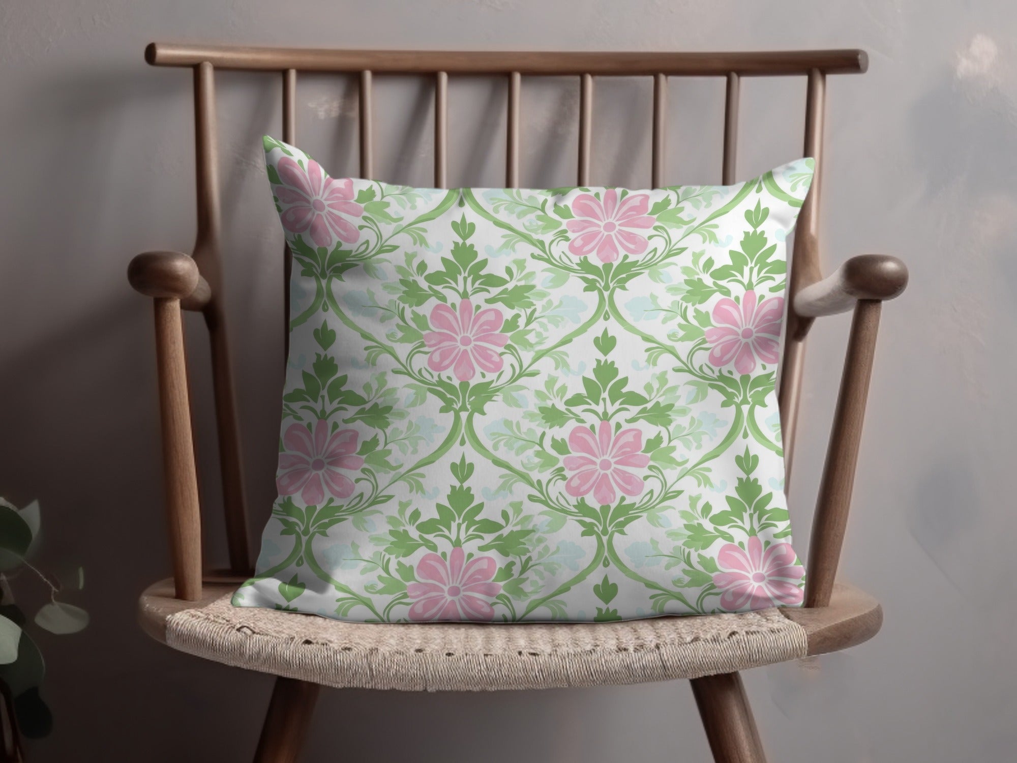 Pillow with pink floral pattern on a wooden chair.
