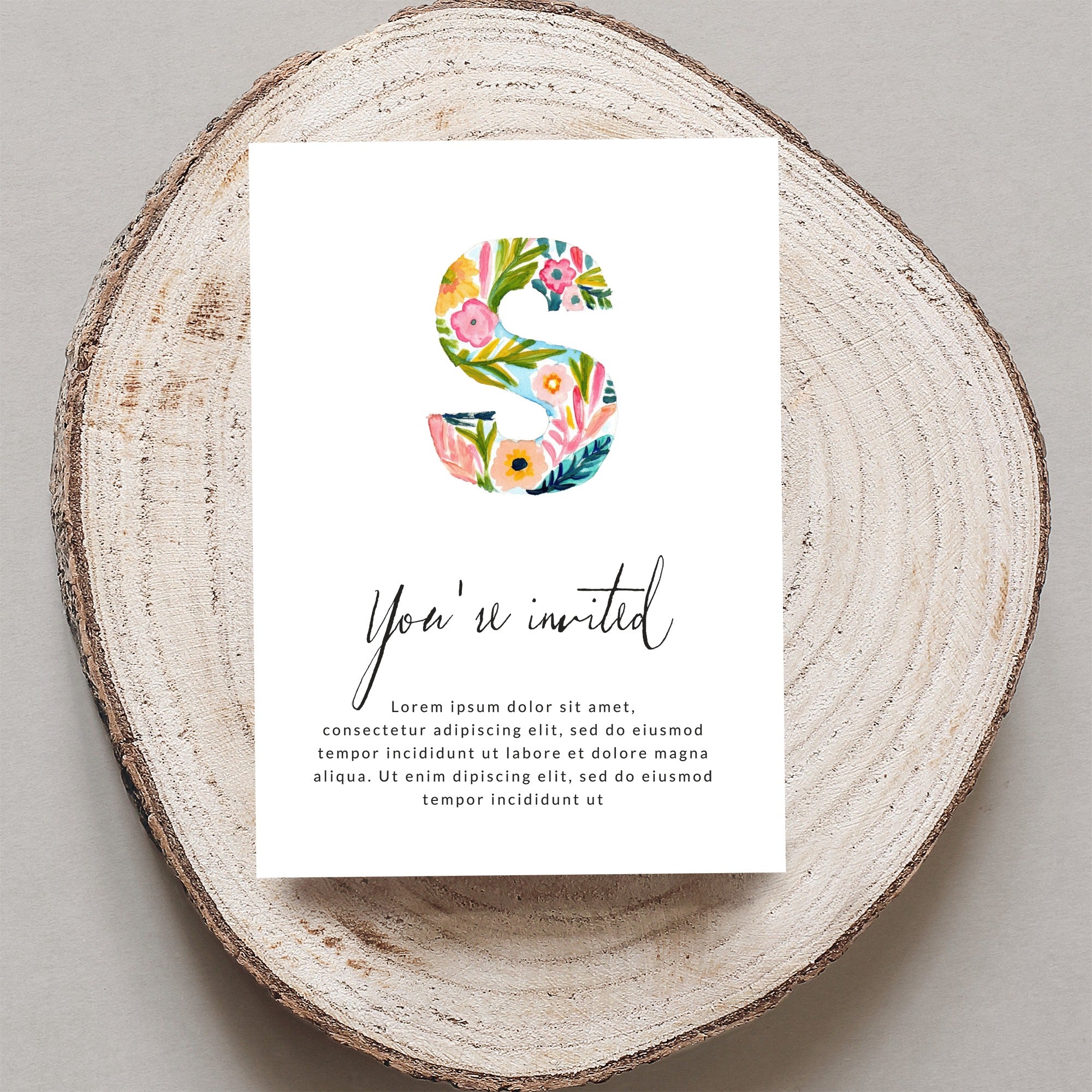 Floral letter S invitation with "You're invited" text.