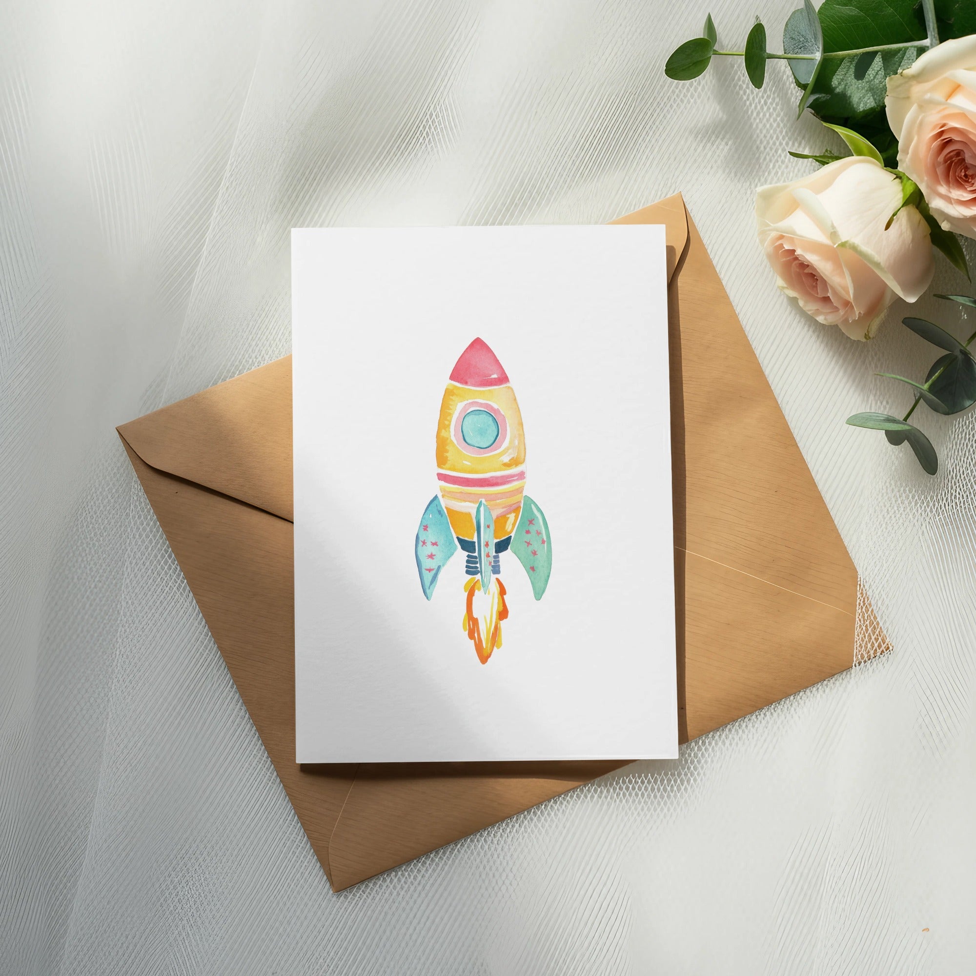 Watercolor rocket card on brown envelope with roses and eucalyptus.
