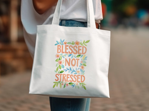 White tote bag with "Blessed Not Stressed" text and floral design.