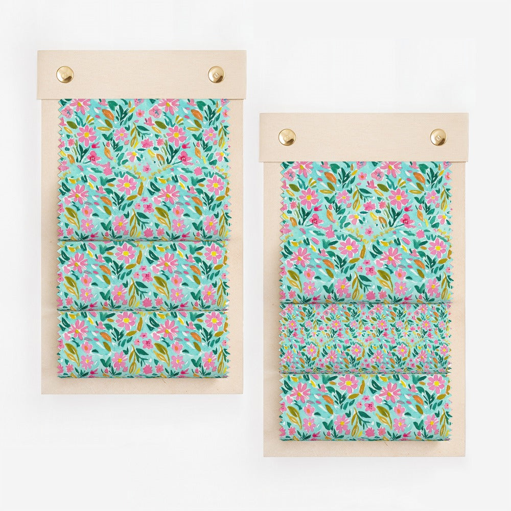 Two fabric swatch books with teal background floral pattern.