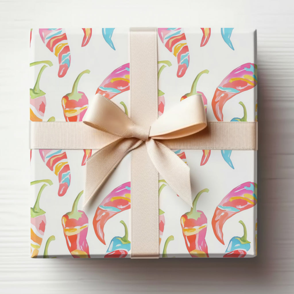 Gift-wrapped box with colorful chili peppers and a beige ribbon.