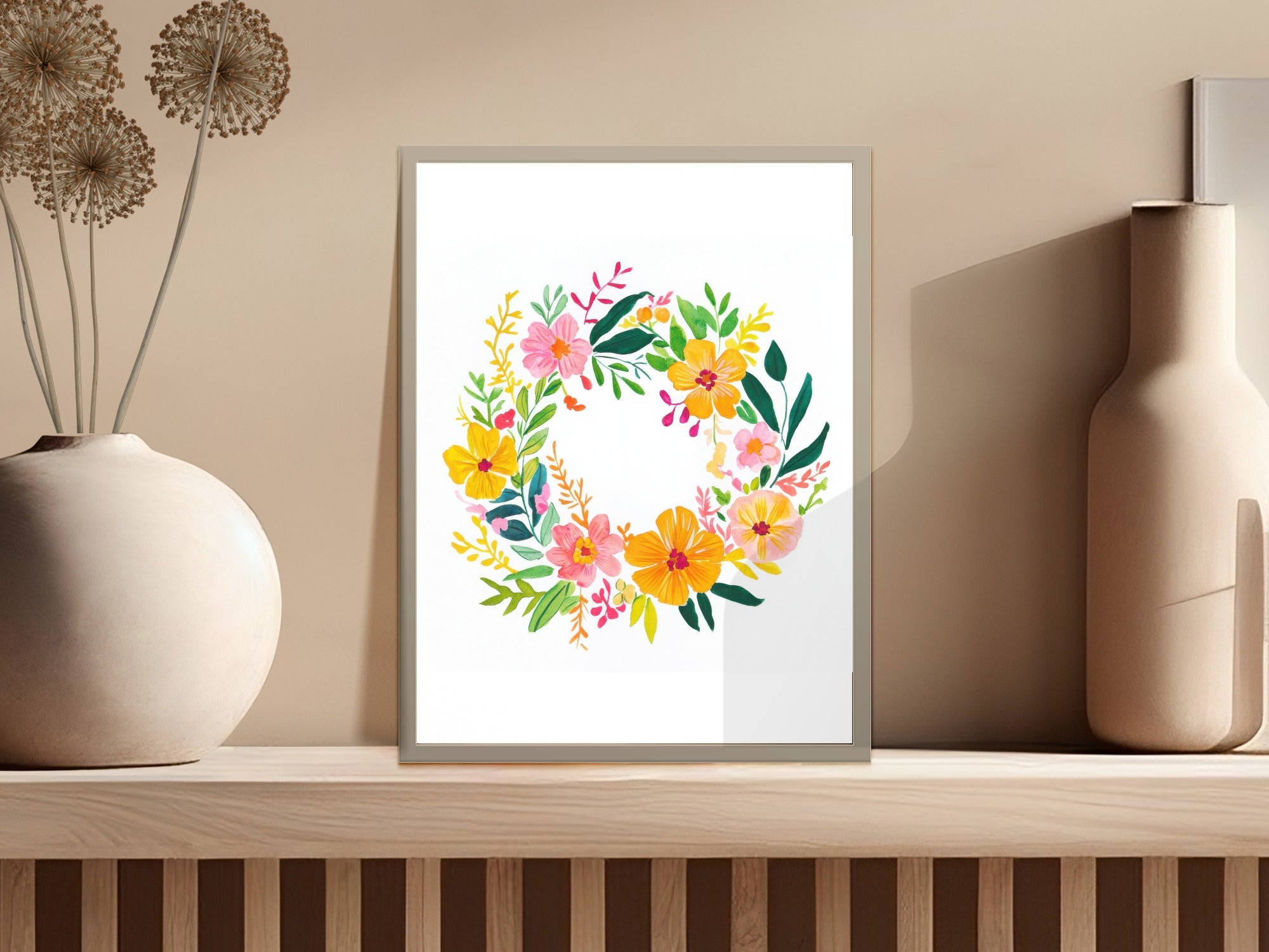 Floral wreath artwork in a light frame on a shelf.