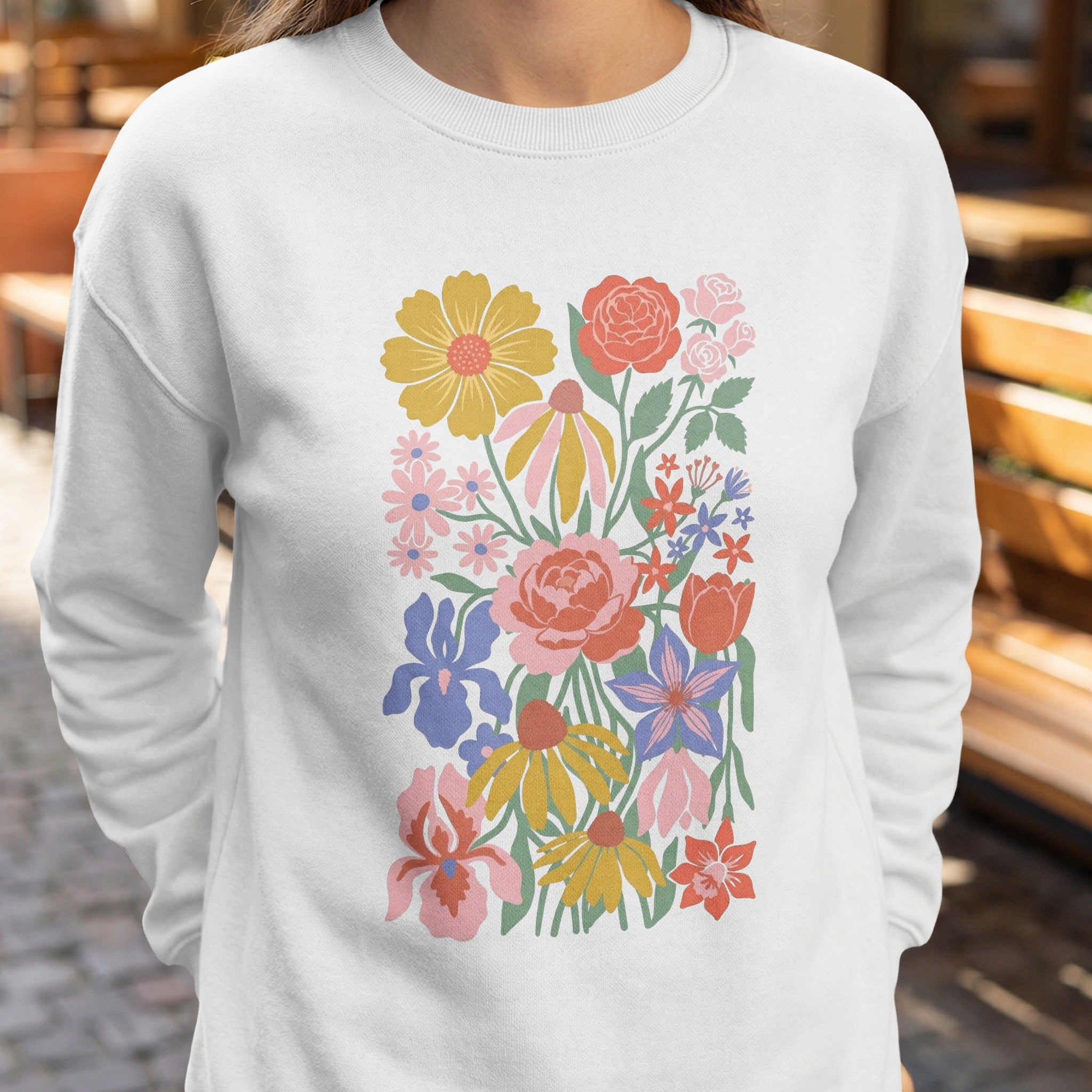 White sweatshirt with a colorful floral illustration.