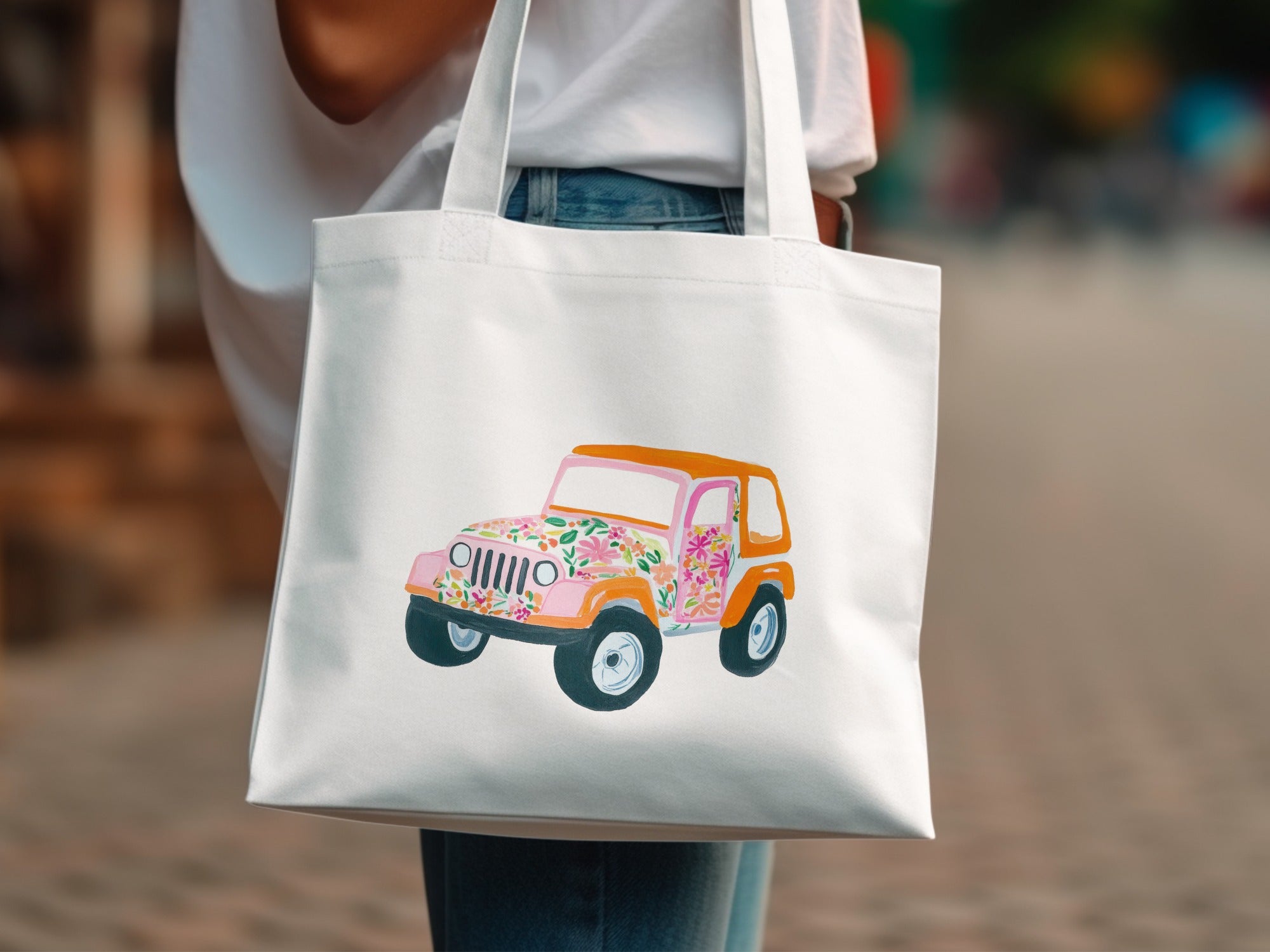 White tote bag with colorful floral-patterned Jeep illustration.