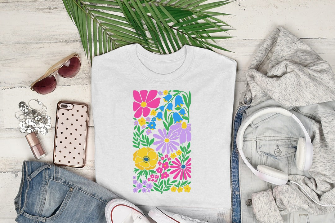 White t-shirt with colorful floral pattern and green leaves.