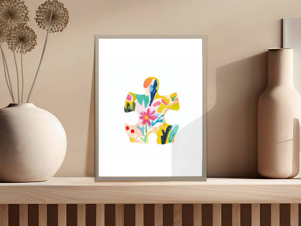 Colorful abstract puzzle piece artwork in a frame on a shelf.