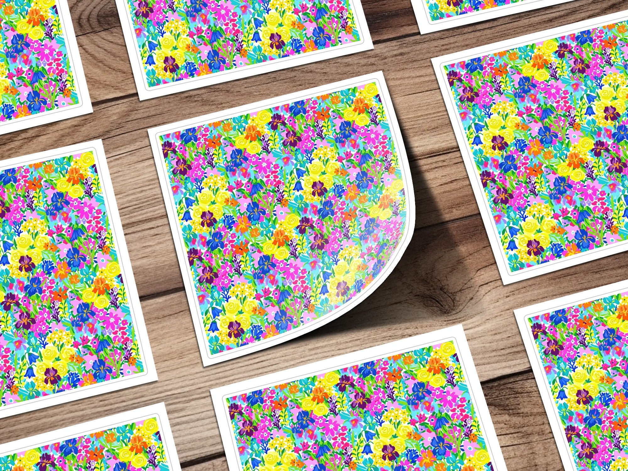 Floral pattern design with colorful flowers on white paper, laid out on wood.